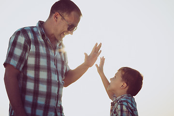 Image showing Father and son playing in the park at the sunset time.