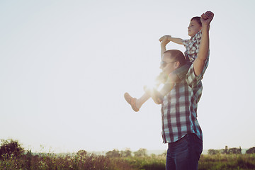 Image showing Father and son playing in the park at the sunset time.