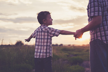 Image showing Father and son playing in the park at the sunset time.