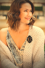 Image showing smiling beautiful woman with a black cameo brooch