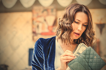 Image showing woman counts the cash in her wallet