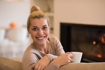 Image showing woman with a mug near a fireplace