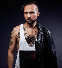 Image showing A man with tattooes on his arms. Silhouette of muscular body. caucasian brutal hipster guy with modern haircut, looking like criminal