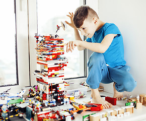 Image showing little cute preschooler boy playing lego toys at home happy smil