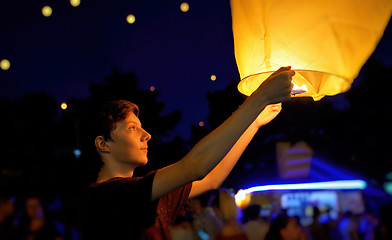 Image showing Teen boy with paper flying lanterns