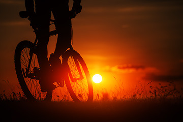 Image showing Silhouette of a bike on sky background during sunset