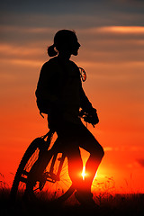 Image showing Silhouette of a bike on sky background during sunset