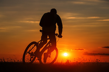 Image showing Silhouette of a bike on sky background during sunset