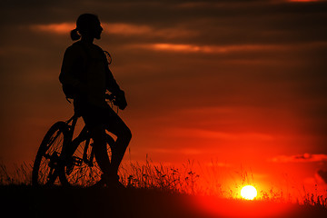 Image showing Silhouette of a bike on sky background during sunset