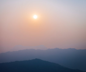 Image showing Sun and haze with silhouetted hills
