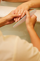 Image showing Closeup shot of a woman in a nail salon receiving a manicure by 