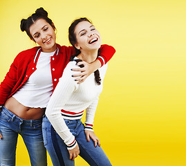 Image showing lifestyle people concept: two pretty young school teenage girls having fun happy smiling on yellow background
