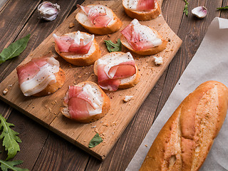 Image showing Appetizing bread with bacon, greens