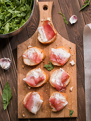 Image showing Appetizing baguette with bacon , greens