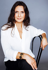 Image showing pretty brunette confident mature woman sitting on chair in studi