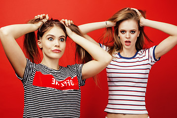 Image showing two best friends teenage girls together having fun, posing emotional on red background, besties happy smiling, lifestyle people concept 