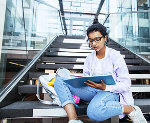 Image showing young cute indian girl at university building sitting on stairs 