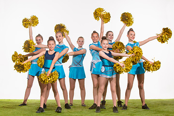 Image showing The group of teen cheerleaders posing at white studio