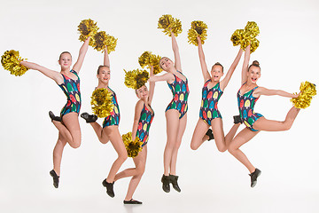 Image showing The group of teen cheerleaders jumping at white studio