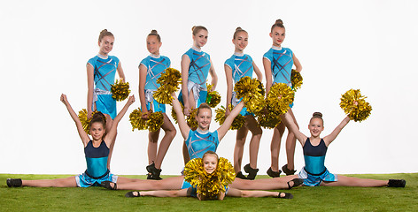 Image showing The group of teen cheerleaders posing at white studio