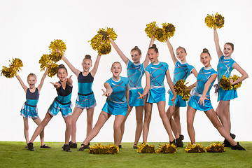 Image showing The group of teen cheerleaders posing at white studio