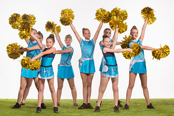 Image showing The group of teen cheerleaders posing at white studio