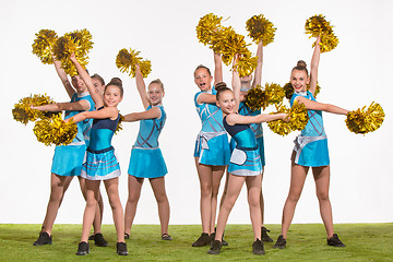 Image showing The group of teen cheerleaders posing at white studio