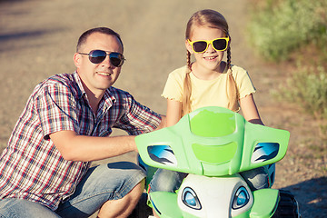 Image showing Father and daughter playing on the road at the day time.