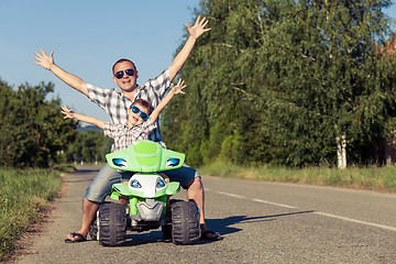 Image showing Father and son playing on the road at the day time.