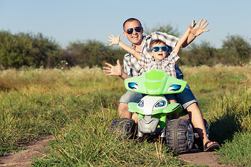 Image showing Father and son playing on the road at the day time.