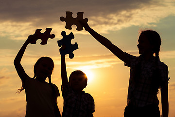 Image showing Silhouette of happy people which playing on the beach at the sun