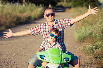 Image showing Father and son playing on the road at the day time.