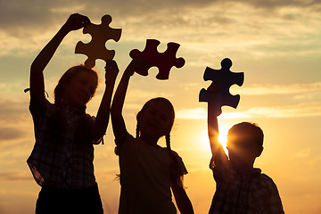 Image showing Silhouette of happy people which playing on the beach at the sun