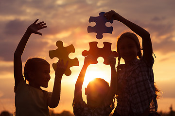 Image showing Silhouette of happy people which playing on the beach at the sun