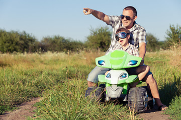 Image showing Father and son playing on the road at the day time.