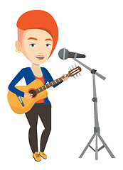 Image showing Woman singing in microphone and playing guitar.