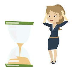 Image showing Desperate business woman looking at hourglass.