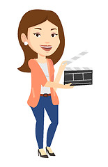 Image showing Smiling woman holding an open clapperboard.