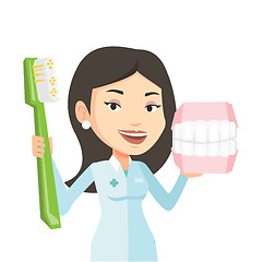 Image showing Dentist with dental jaw model and toothbrush.