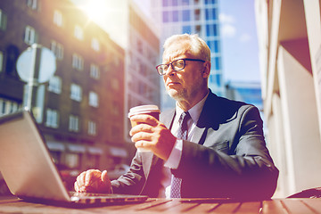 Image showing senior businessman with laptop drinking coffee