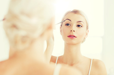 Image showing woman with brush doing eyebrow makeup at bathroom