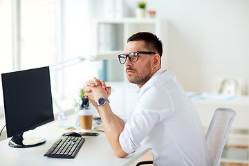 Image showing businessman in glasses sitting at office computer