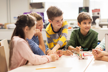 Image showing happy children building robots at robotics school