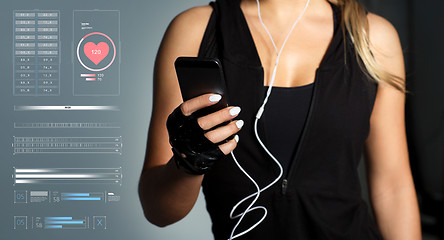 Image showing sportswoman with smartphone and earphones