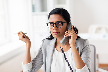 Image showing businesswoman calling on phone at office