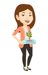 Image showing Woman holding plant growing in plastic bottle.