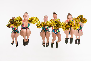 Image showing The group of teen cheerleaders jumping at white studio