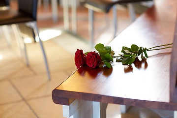 Image showing red roses on bench at funeral in church