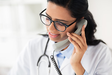 Image showing doctor in glasses calling on phone at hospital