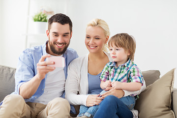 Image showing happy family with smartphone at home